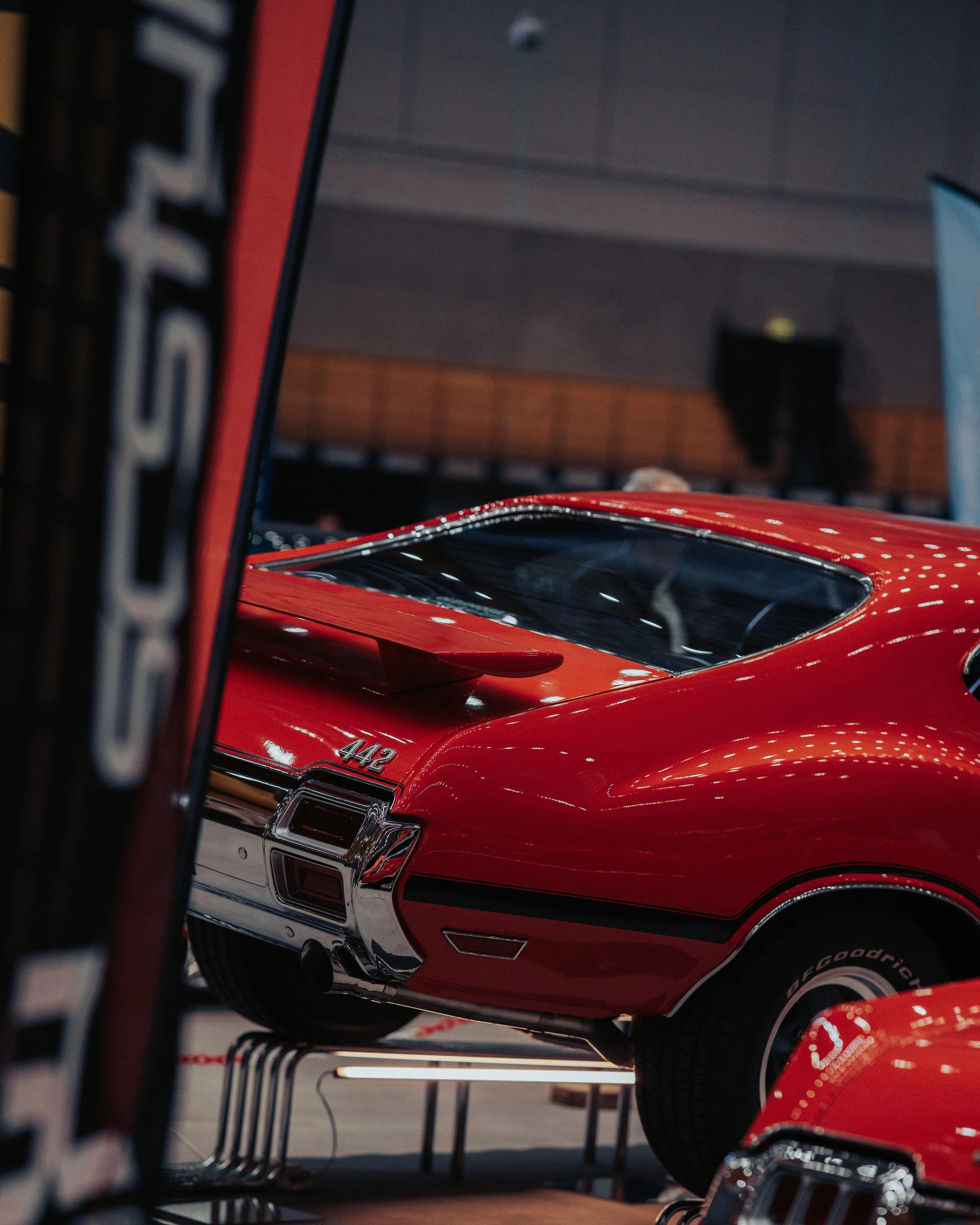Red classic car on display at an indoor car show
