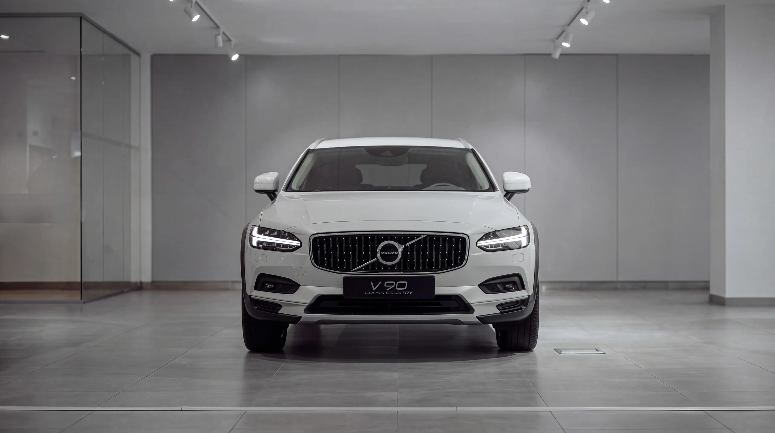 White Volvo estate car in a bright, empty showroom
